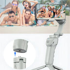 Smartphone, gehalten von einem Danxon Gimbal, mit einem Foto von Personen auf dem Bildschirm vor einem Hintergrund mit Menschen am Pool