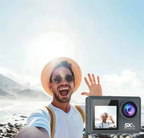 Mann macht Selfie mit Danxon Action Kamera, Videowiedergabe auf Display vor Bergkulisse